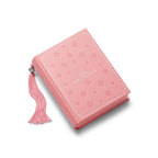 Pink notebook with floral pattern and tassel on a white background