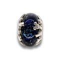 A silver-toned ring featuring an oval dark blue glass charm with a starry galaxy pattern, set against a clean white background with a soft reflection.