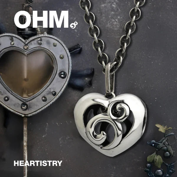 Heart-shaped pendants with intricate designs on a dark background, featuring the brand 'OHM'.