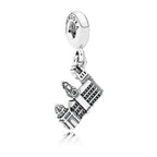 Silver charm with a detailed design on a white background