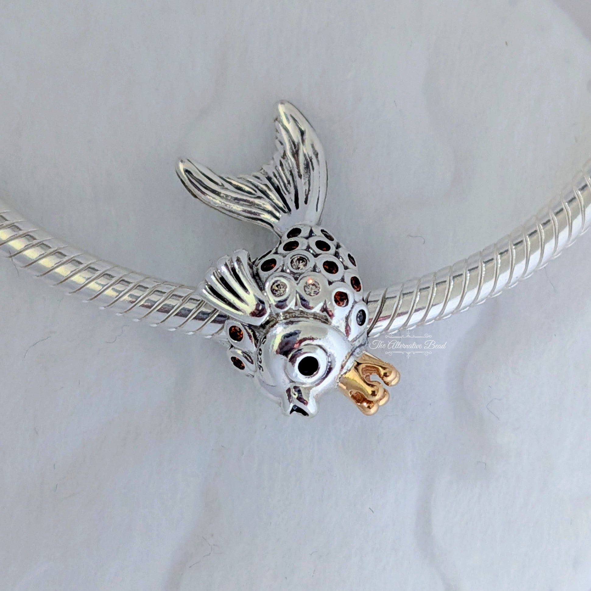 Pandora Fairytale fish silver charm with 14k, orange and golden coloured cubic zirconia and black crystal silver and gold sterling-silver and gold and crystal Bead by The Alternative Bead. Your Jewelry Retailer from Germany