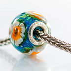 VIP-CHARMS Daffodil Paradise Bead blue; green; white; orange glass Bead by The Alternative Bead. Your official VIP-CHARMS Retailer from Germany
