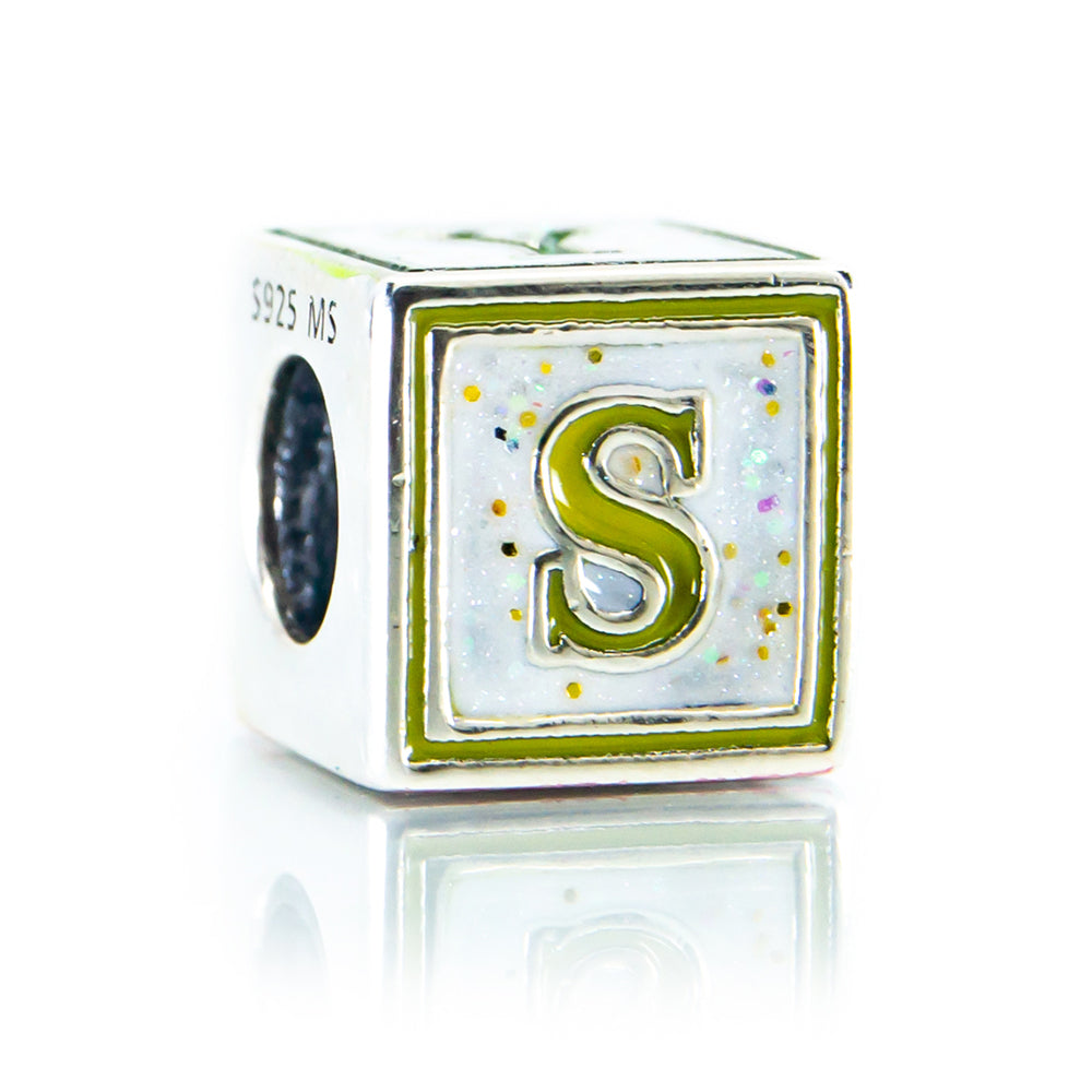 Cube-shaped charm with letter 'S' on a white background